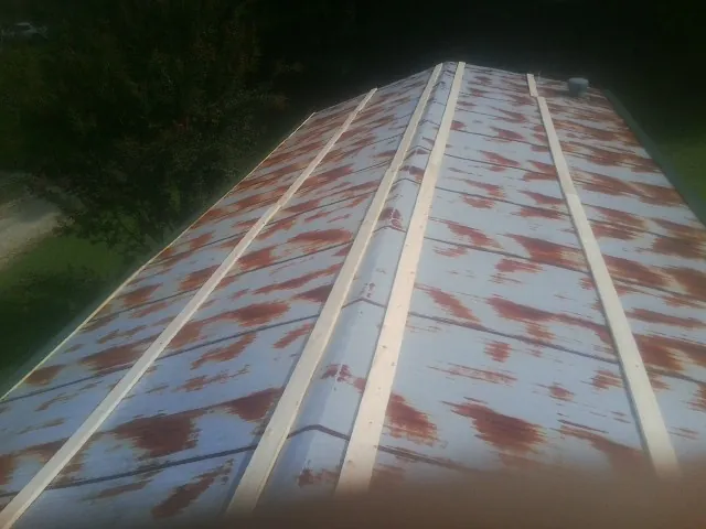 Rusted metal roof panels with new wood purlins before replacement — Storm Damage Roof Repair in Kirkland by Roofing Brothers